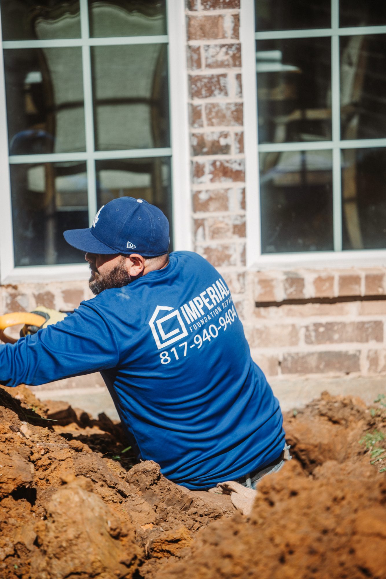 Crew in trench branded, Imperial Foundation Repair job site in North Texas