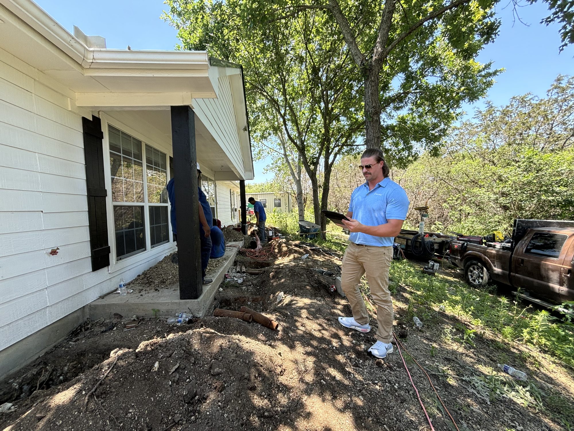 Rep inspecting exterior, Imperial Foundation Repair job site in North Texas
