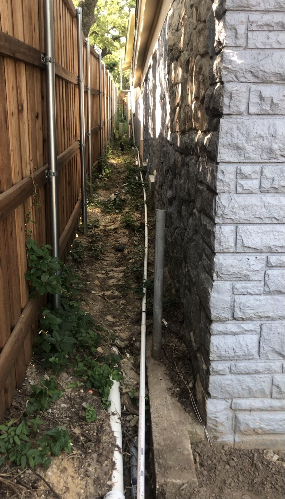 Narrow side yard drain line, Imperial Foundation Repair job site in North Texas