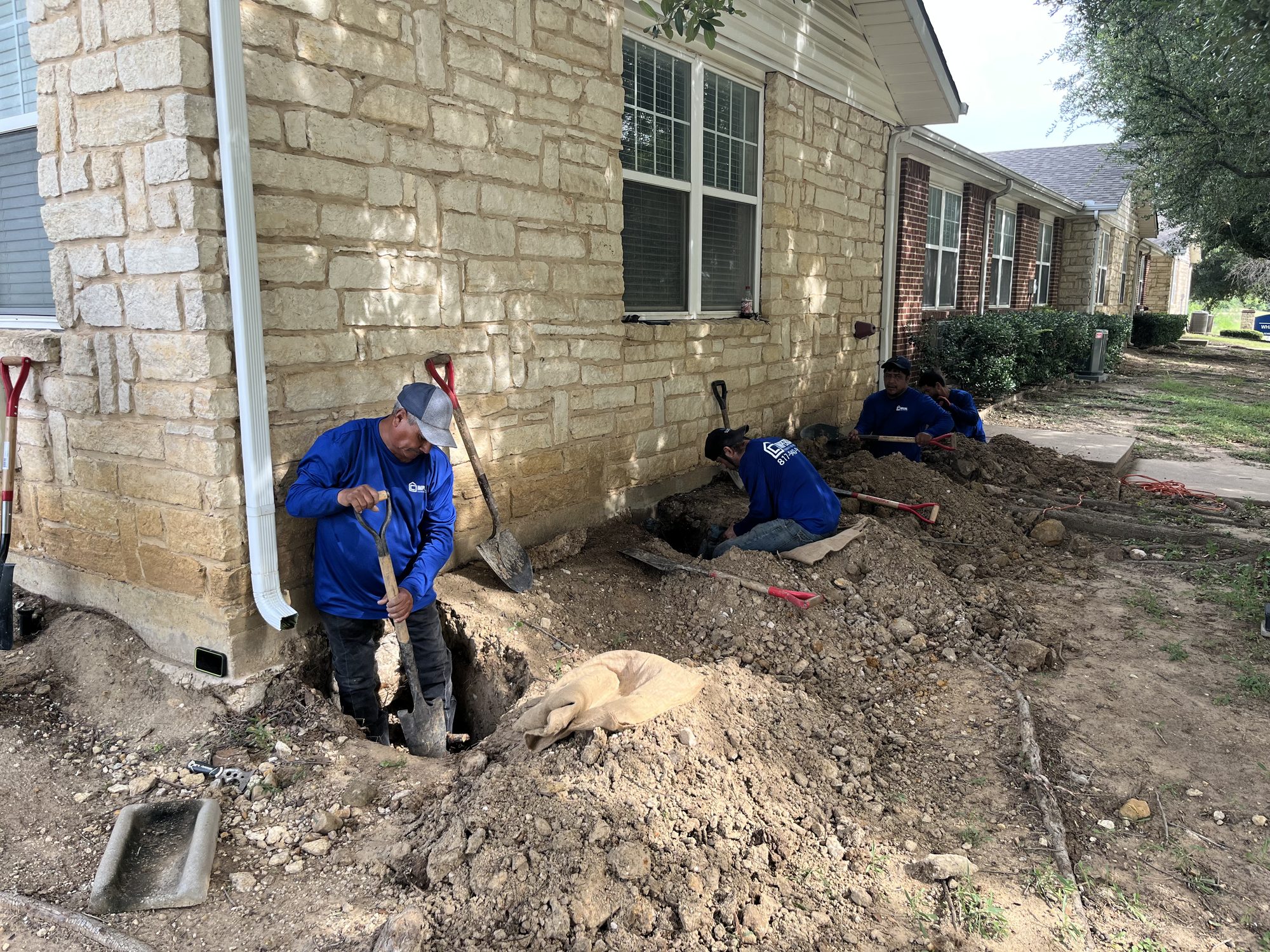 Crew excavation limestone, Imperial Foundation Repair job site in North Texas