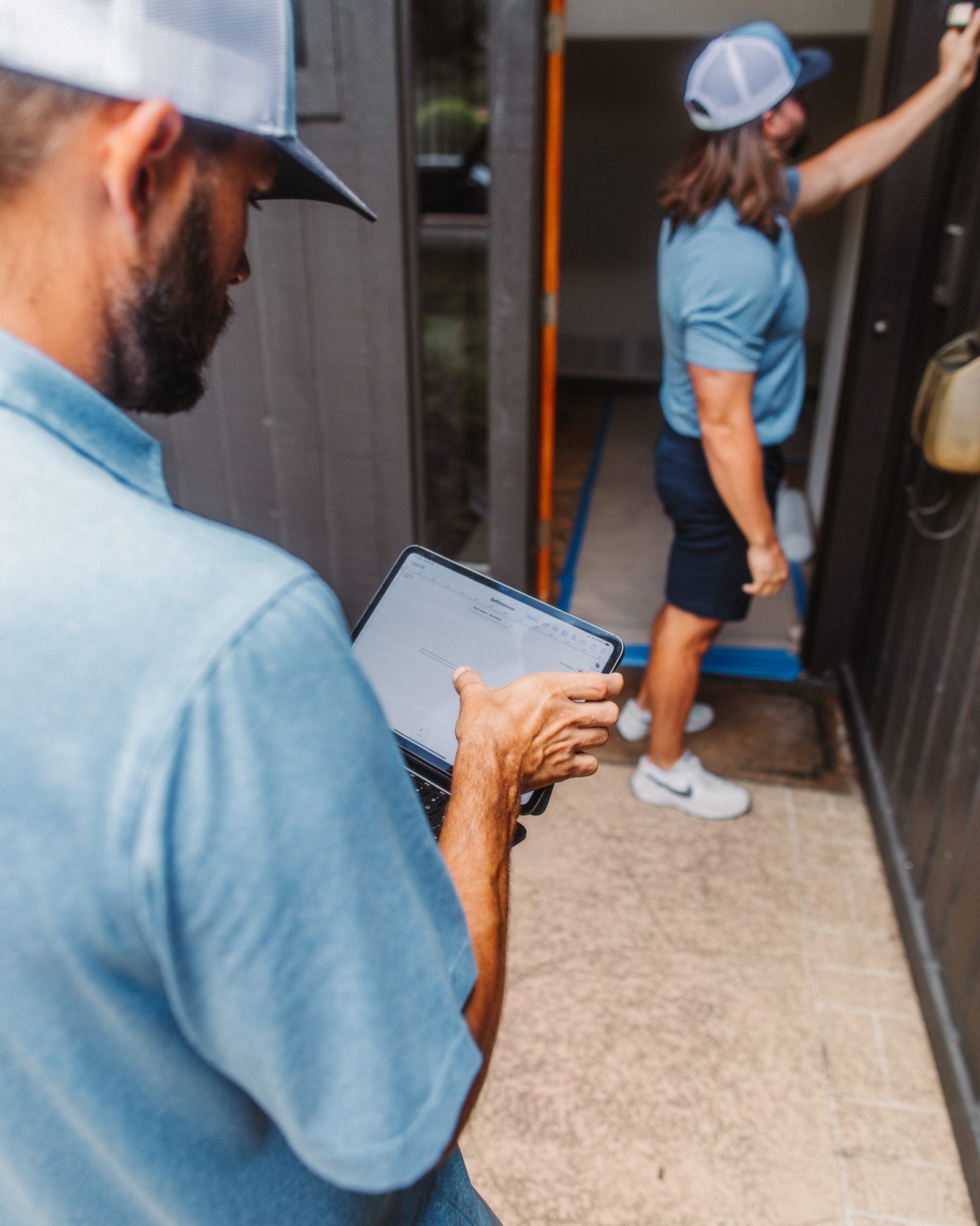 Inspect door with tablet, Imperial Foundation Repair job site in North Texas